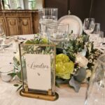 centre de table fleuri blanc et vert, feuillage et bougies