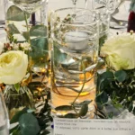 mariage grands vins, centre de table vases droits, bougie flottante et fleurs